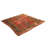 A Wilton Persian style rug, the brick red ground with formal flowerhead pattern, within multiple