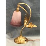 A brass arts and crafts style tablelamp, the signed Rethondes bell form glass shade on a curved loop