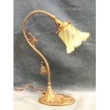 A brass art nouveau style tablelamp, the frosted mouth blown vaseline glass spiral shade on a