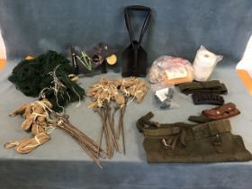 Miscellaneous rabbiting gear including stakes, nets, cartridge belts, twine, a folding shovel,