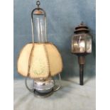 A hanging chromed oil lamp with stencilled parchment octagonal shade and tall chimney; and a