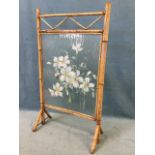 A bamboo framed rectangular firescreen handpainted on ribbed glass with white anenome flowers, the