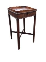 A George III mahogany urn table, the square galleried top above a frieze with slide and cast brass