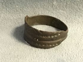 An ancient C10th - C12th Viking style ring, the ribbed band with dimpled and engraved design.