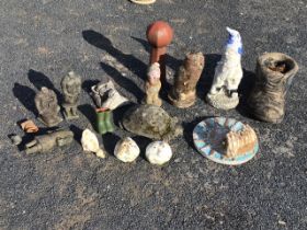 A collection of small composition stone and terracotta garden ornaments including garden gnomes,