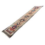 A Heriz runner, the brick red ground with six medallions, within forma floral (36.5in x170in)