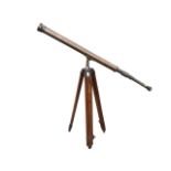 An early 20th century brass telescope with adjustable focus, 1.5in lens and brass cap, on a mahogany