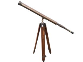 An early 20th century brass telescope with adjustable focus, 1.5in lens and brass cap, on a mahogany
