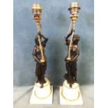 A pair of late 18th century figural candlesticks, the patinated bronze classically draped female