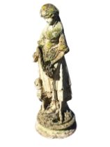 A composition stone figure of a standing shepherdess with a lamb, on a circular moulded plinth.