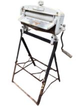 A 1950s Acme manual laundry mangle, mounted on a wrought iron stand. (28in x 20.5in x 44in)