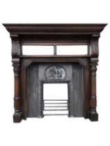 A Victorian oak chimneypiece in the Jacobean style, with cast iron insert, the gadrooned moulded