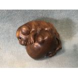 A Japanese hardwood netsuke of a pair of frolicking puppies with inset eyes and inlaid mother-of-