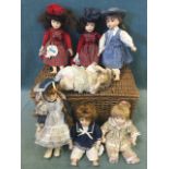A cane hamper containing seven Promenade Collection handpainted porcelain headed character dolls. (