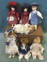 A cane hamper containing seven Promenade Collection handpainted porcelain headed character dolls. (