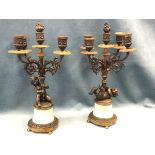 A pair of bronze candelabra, each with five urn shaped swagged candleholders on foliate scrolled