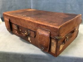 An early 20th century leather suitcase, by Dog Brand, Shanghai, with nickel fittings and leather