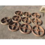 A set of ten cast iron wheels, each with moulded rims and four rectangular spokes around 3.5in