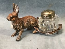 A Victorian Bergman style cold painted metal hare inkwell with metal mounted glass ink bottle. (