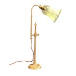 A brass arts and crafts style reading lamp, the mouth blown ribbed bell form vaseline glass shade on