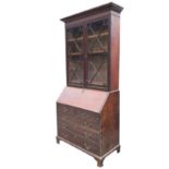 A George III mahogany bureau bookcase, the flared cornice above astragal glazed doors, enclosing