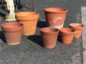 Six terracotta flowerpots, the largest hand thrown, another with impressed floral pattern to the