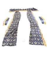 A pair of blue brocade lined and interlined curtains, tie-backs and pelmet, woven in a gold floral