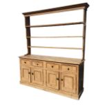 A Victorian pine dresser, the moulded cornice above an open delft rack with three graduated shelves,