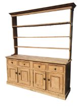 A Victorian pine dresser, the moulded cornice above an open delft rack with three graduated shelves,