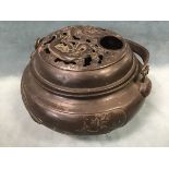 An 18th century Japanese bronze censer, the pierced cover cast with a dragon and bird above a