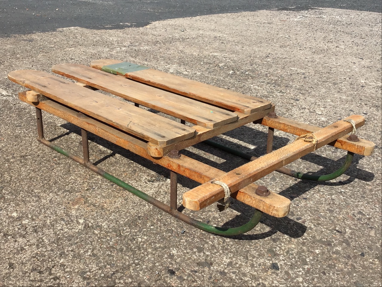 A C20th sledge with hardwood slatted frame, raised on tubular rails; a green faux-leather - Image 3 of 3