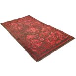 A mid-19th century Wilton rug, the dark brick-red ground with allover scrolling floral arabesque