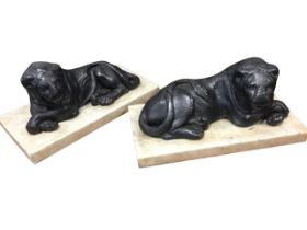 A pair of Victorian lead lions, the beasts lying on rectangular marble plinths with crossed paws. (