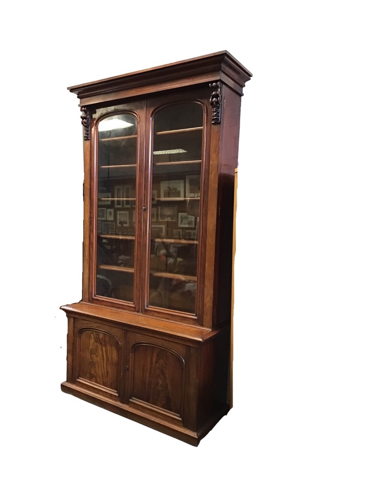 A Victorian mahogany bookcase, the moulded cornice above a pair of arched glazed doors flanked by