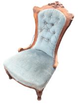 A Victorian walnut button upholstered chair with scroll carved back above a sprung seat, raised on