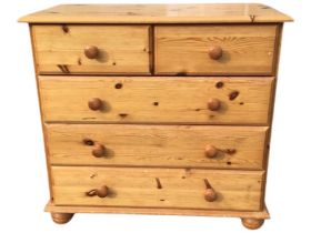 A pine chest of drawers, the rectangular top above two short and three long drawers mounted with