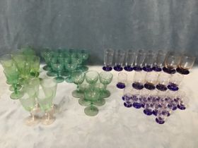 Three sets of coloured drinking glasses - floral engraved on blue bases, faceted pale green on