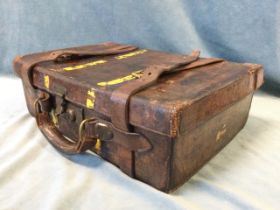 An antique leather cartridge case with brass hasp lock and leather handle and straps, opening to six