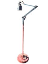 An industrial style adjustable spotlight revolving on a painted column with cleats for cable, raised