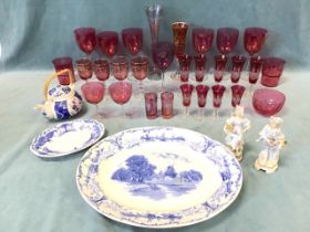 A collection of cranberry glass including sets of drinking glasses, some engraved, a bowl, a pair of