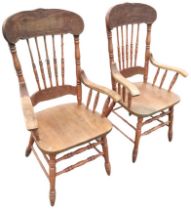 A pair of C20th American oak country armchairs, the carved crestrails above spindle backs and
