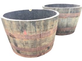 A pair of oak half barrels of staved construction with iron hoops, one with drilled base. (25.5in