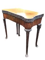 An 18th century mahogany triple-top games table, the panels with ribbon and flowerhead carving