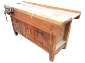 A rectangular workbench, the channeled top having deep aprons mounted with a Record cast iron