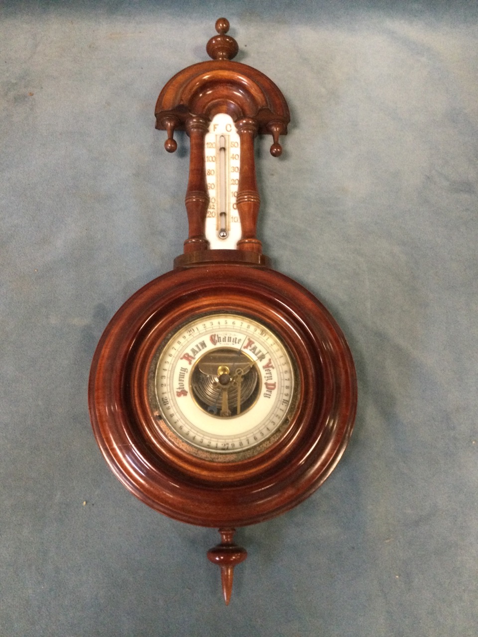An Edwardian mahogany cased banjo barometer with arched moulded back above a thermometer framed by