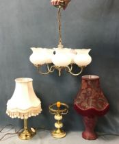 A brass five-light chandelier with glass shades; a brass and onyx tablelamp; a brass tablelamp