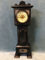 An Edwardian ebonised miniature grandfather clock, the enamelled dial with arabic numerals under