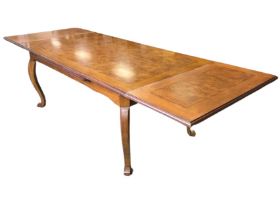 A mahogany and burr wood extending dining table, the moulded top with two pull-out leaves above a