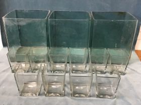 Three large mottled glass foot square terrariums; and a set of ten heavy square glass tapering