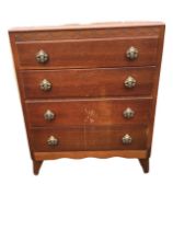 A 1950s oak chest of drawers, the carved frieze above four graduated drawers with pierced cast brass